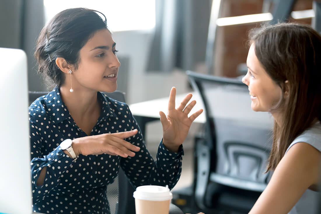 Young women talking in an office setting